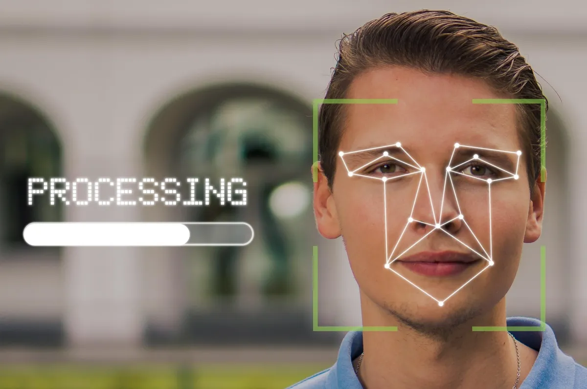 Férfi arca arcfelismerő pontokkal és „Processing” felirattal
